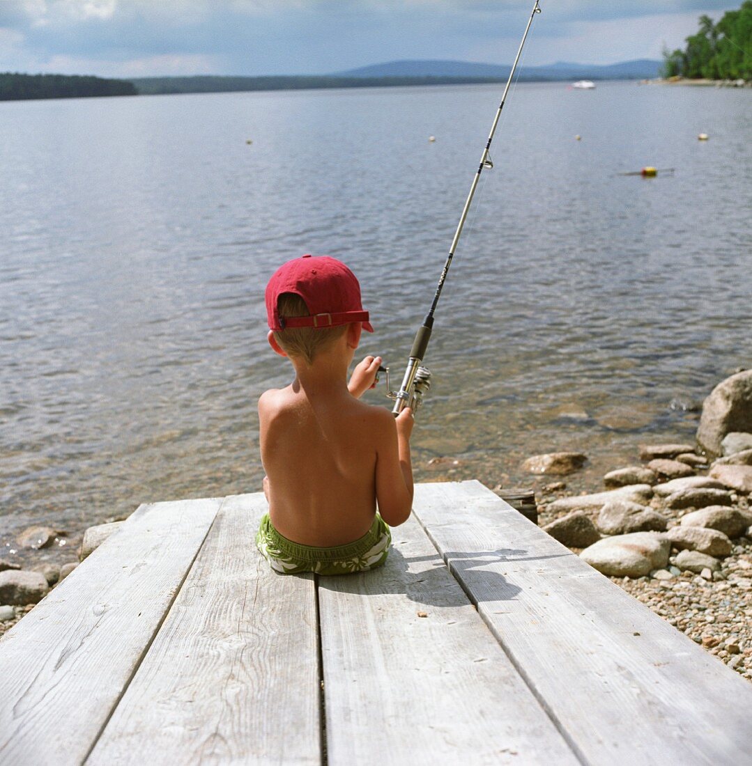 Kleiner Junge angelt am See