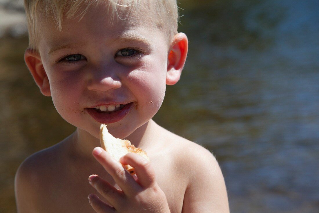 Kleiner Junge isst ein Stück Brot