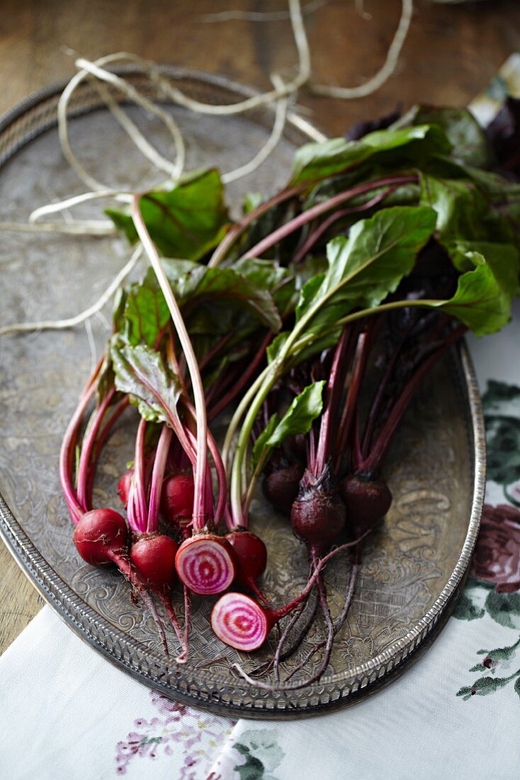 Beetroot, whole and cut in half, on a metal tray