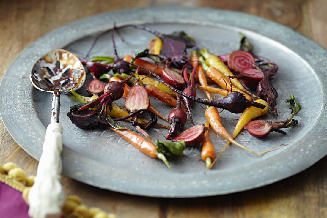 Roasted root vegetables on a plate with a spoon