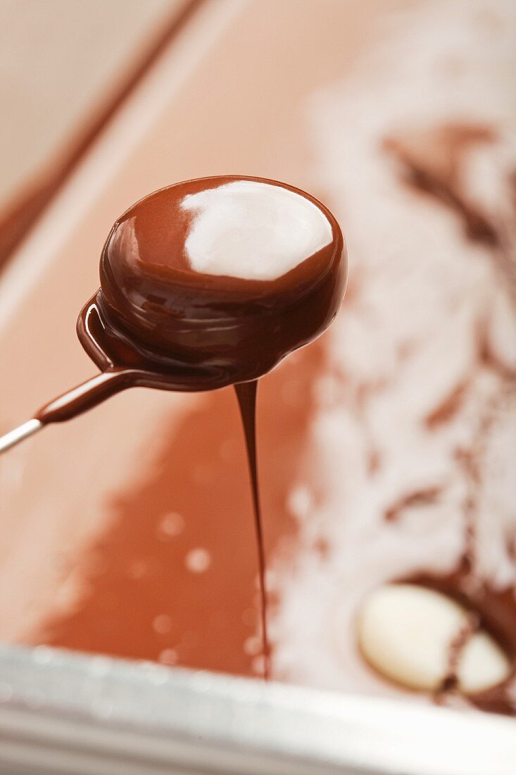 Schokolade tropft von einer Praline