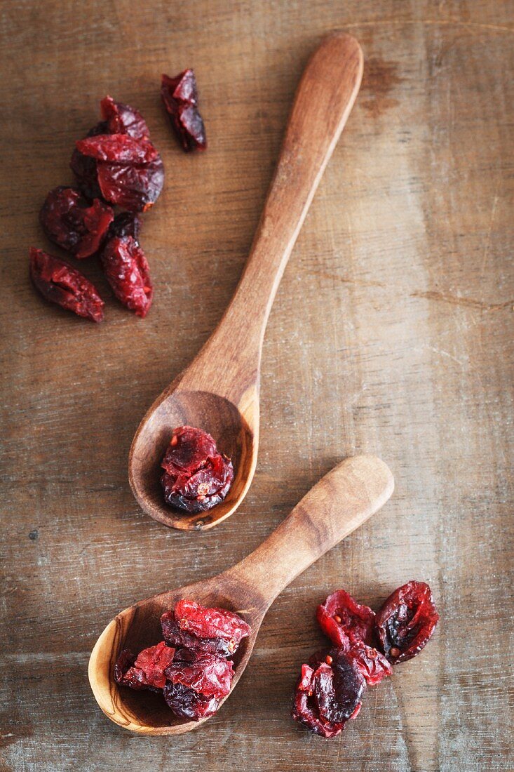Dried cranberries and two wooden spoons