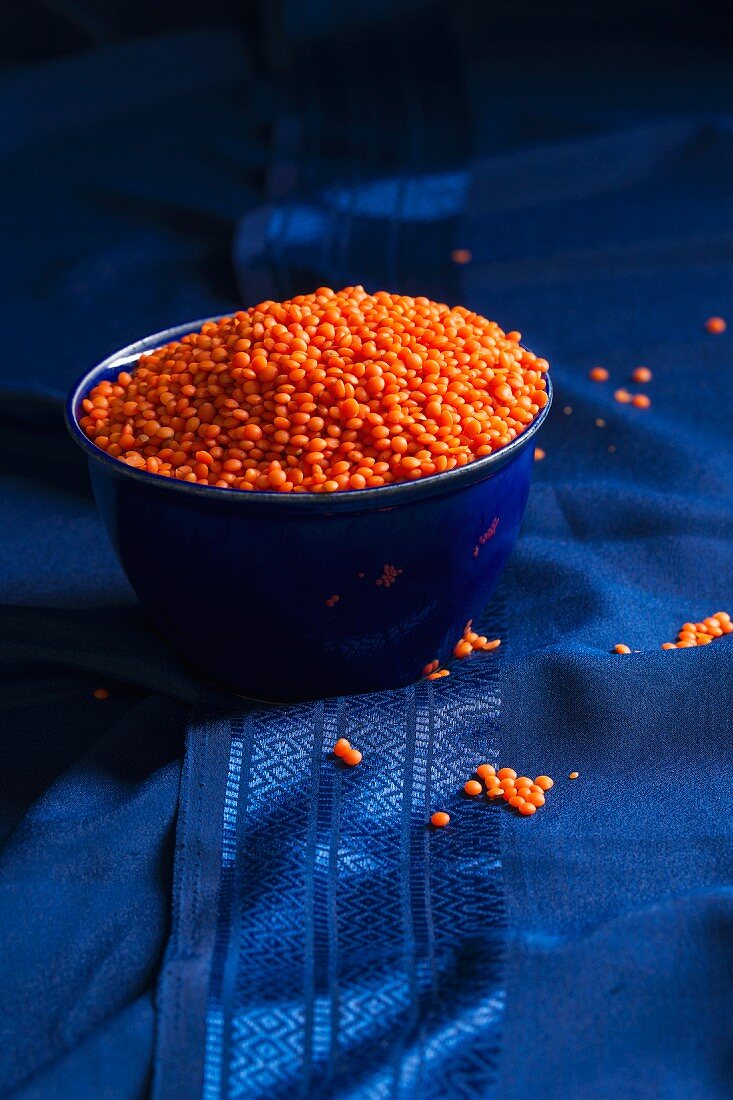 Red lentils in a blue bowl on a blue silk sari