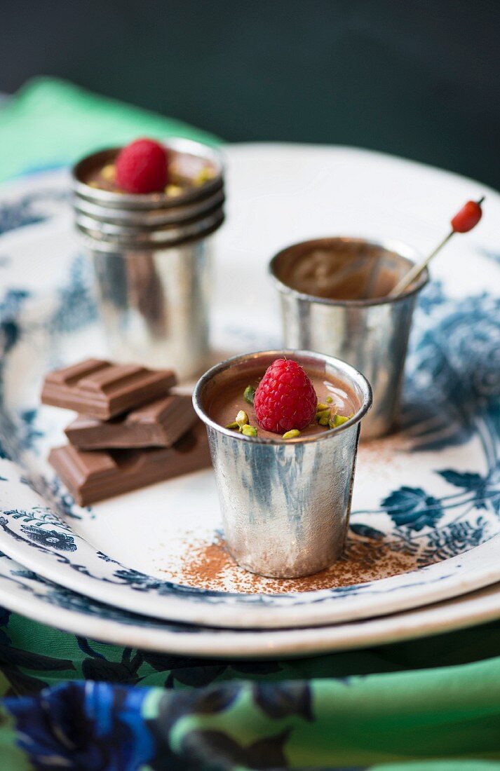 pots of chocolate and raspberry mousse on a vintage plate