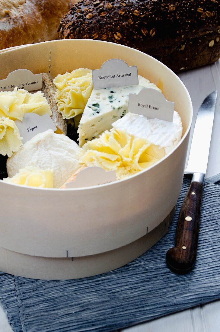 Assorted types of French cheese in a woodchip box