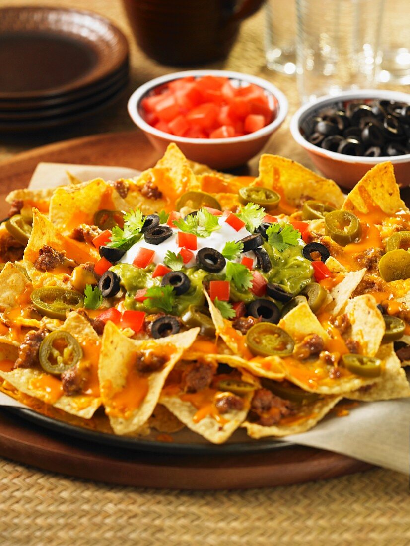 Nachos with cheese sauce, olives, tomatoes, coriander and sour cream (Mexico)