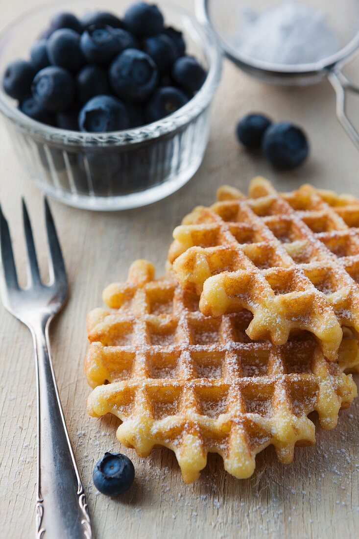 Waffeln mit Puderzucker und frischen Heidelbeeren