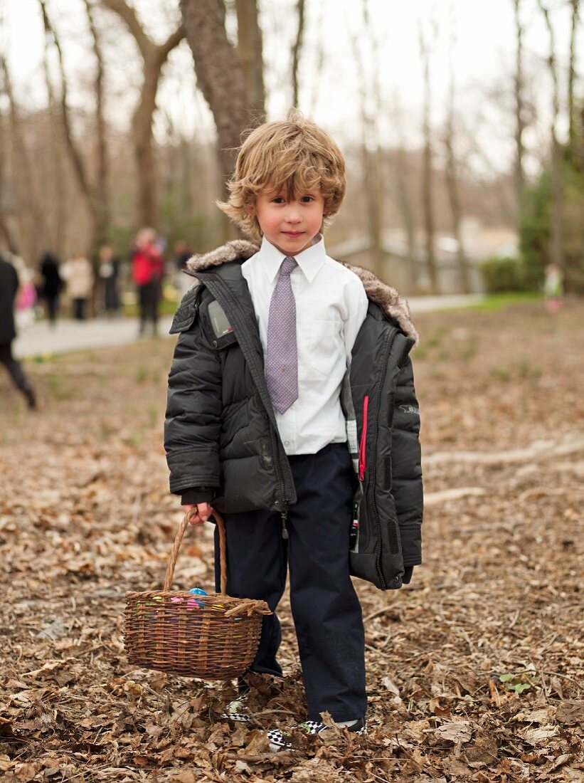 Kleiner Junge bei der Ostereiersuche im Park
