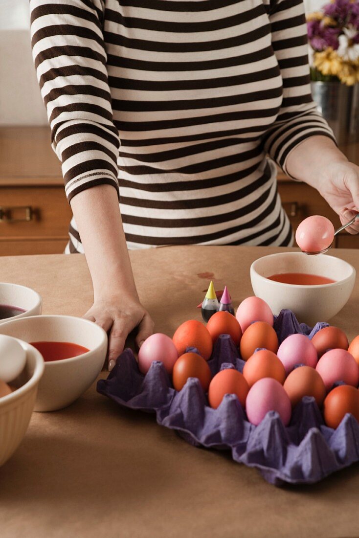 A woman colouring Easter eggs