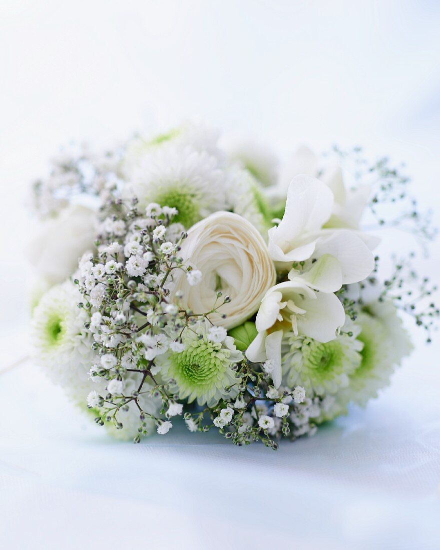A white wedding bouquet with baby's breath, roses and gerberas