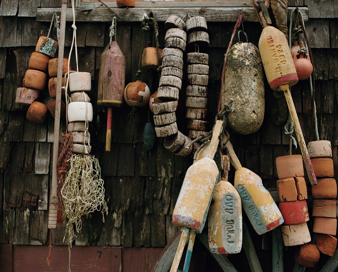 Fischereiutensilien an einer rustikalen Holzwand hängend