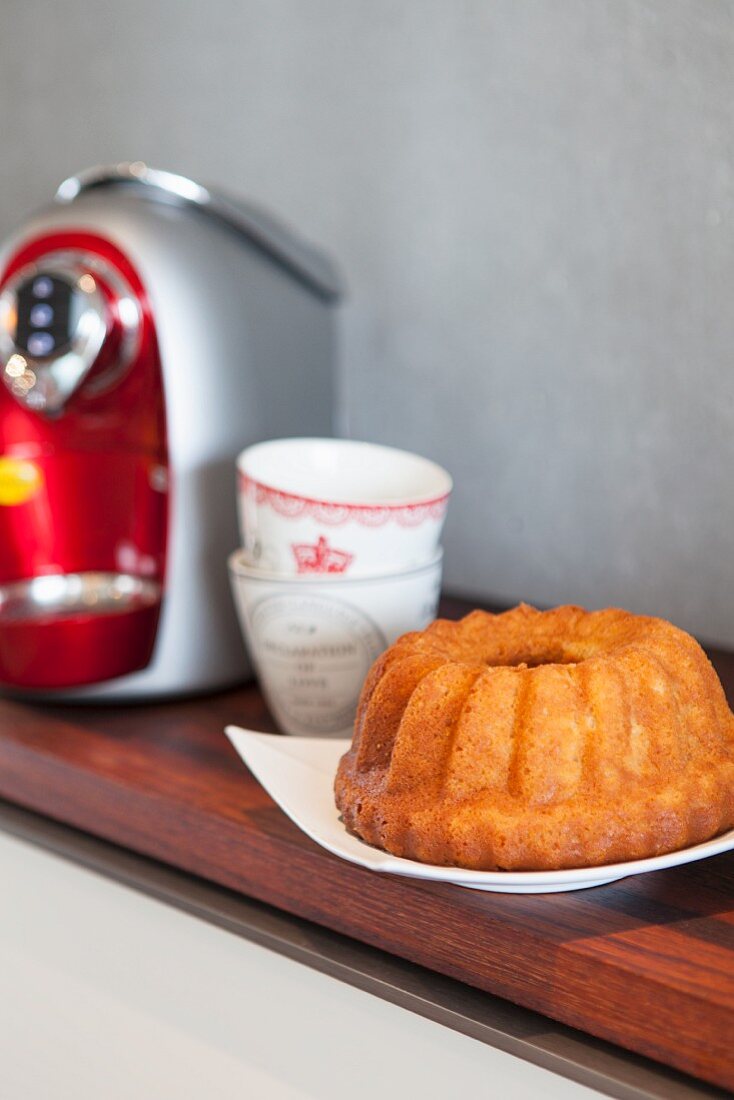 A Bundt cake next to a coffee machine