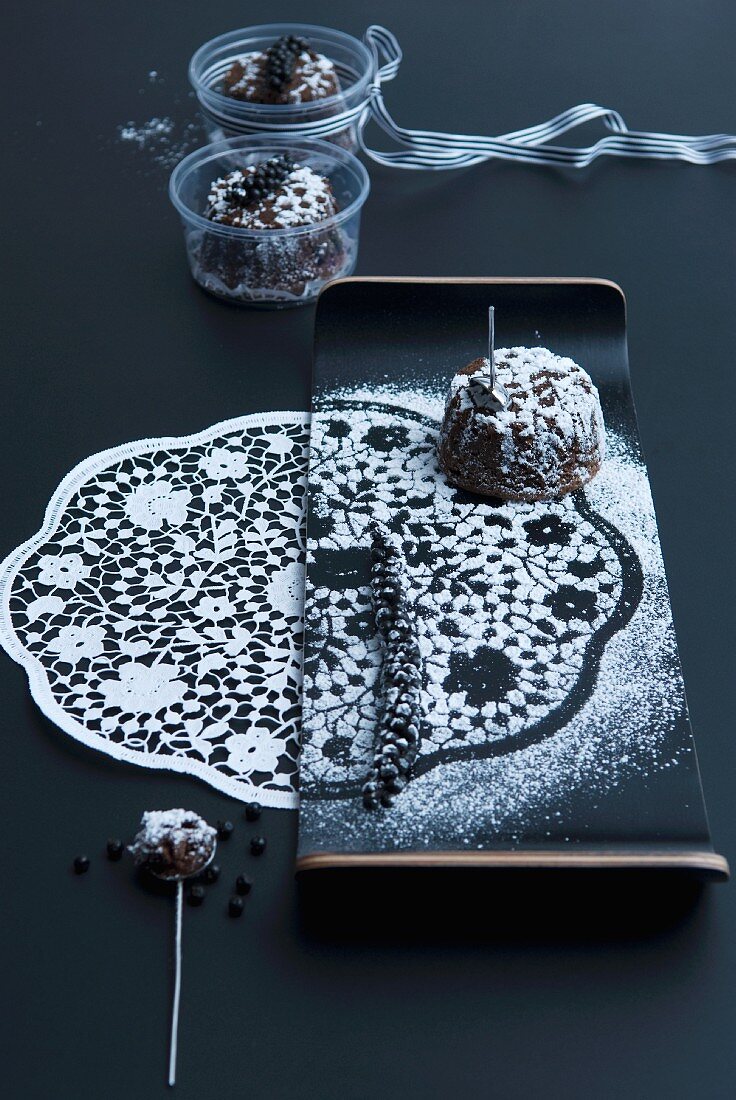 A print of a doily in icing sugar with a chocolate cake on an elegant plate