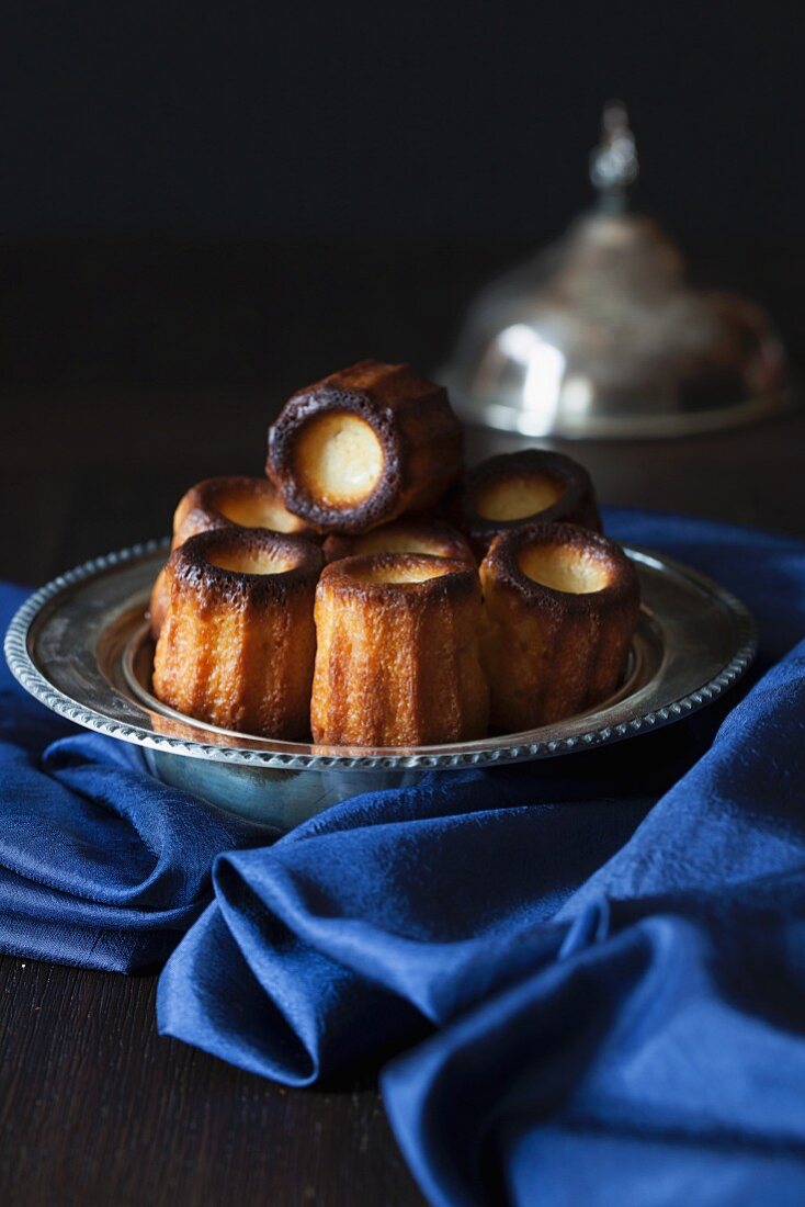 Canelés de Bordeaux (French sweet little treats) in silver bowl