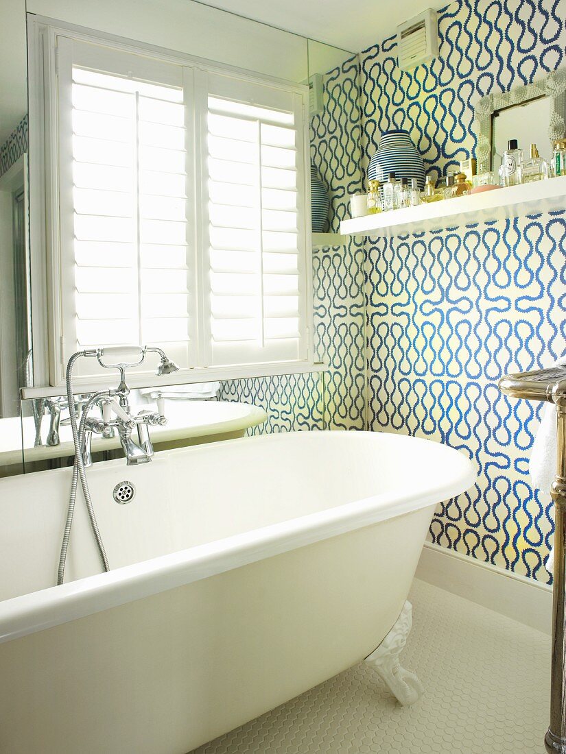 Snaking, Vivienne Westwood pattern in bathroom with free-standing bathtub in front of mirrored wall with window