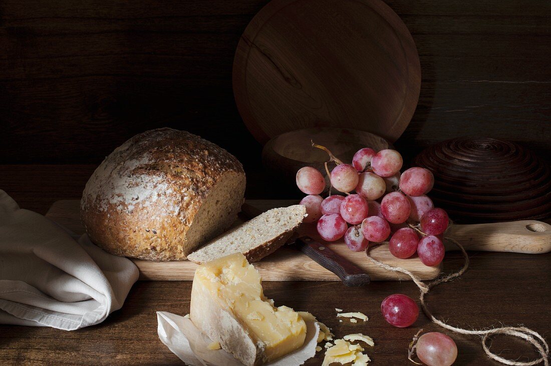 Angeschnittenes Brot, Trauben und Käse