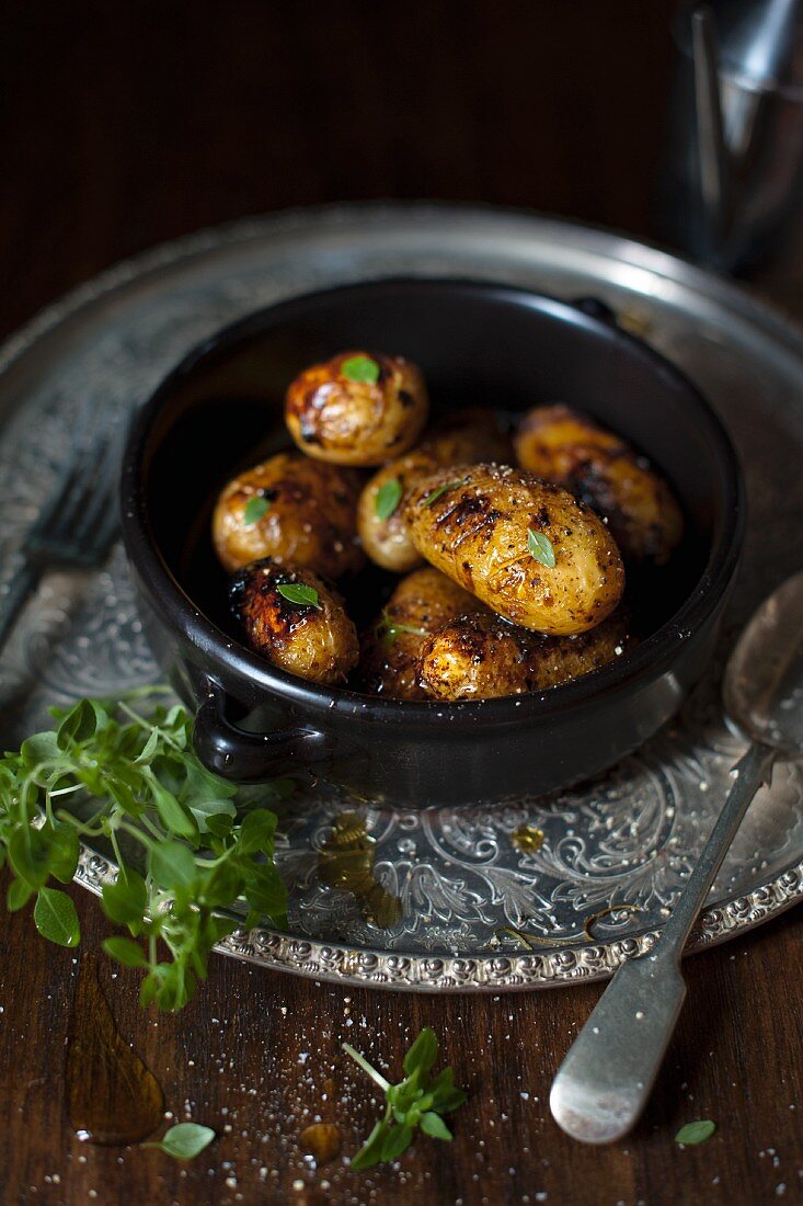 Roasted new potatoes in a bowl with sea salt and greek basil.