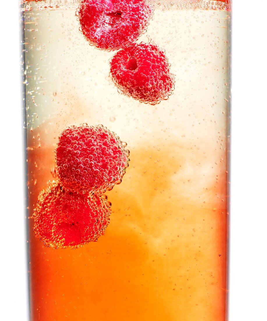 Raspberries in champagne and Aperol (close-up)