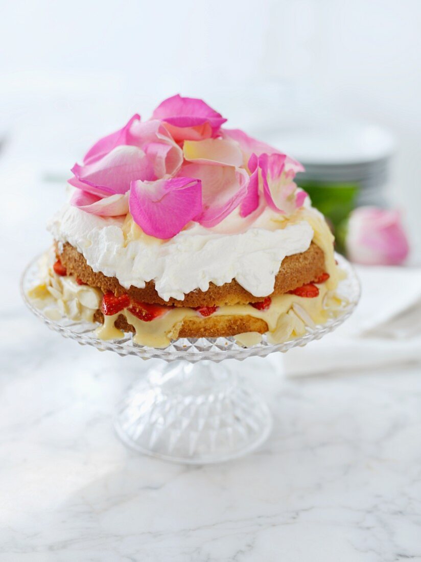 Biskuitkuchen mit Erdbeerfüllung und Rosenblättern