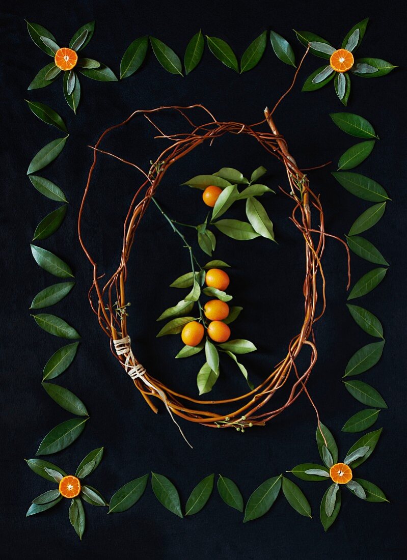 Arrangement aus Kumquats, Blättern und Zweigen