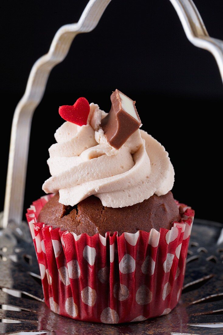 Chocolate cupcake decorated with strawberry cream and a red heart