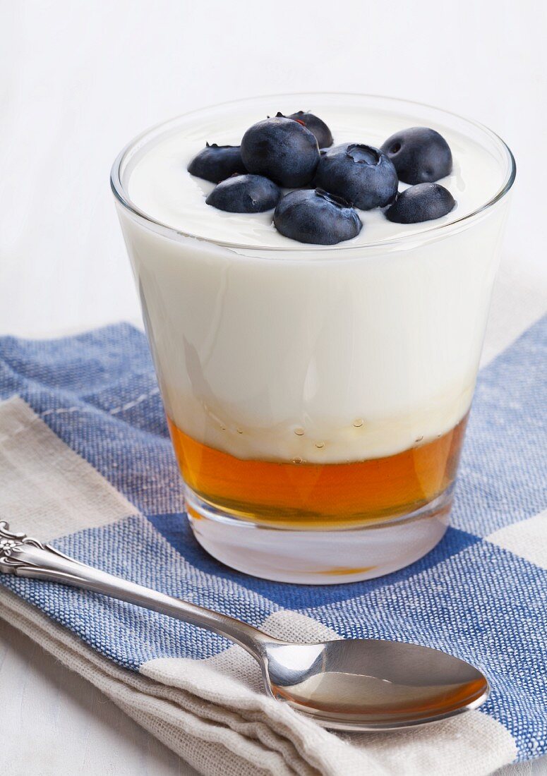 Naturjoghurt auf Honig mit Blaubeeren im Glas