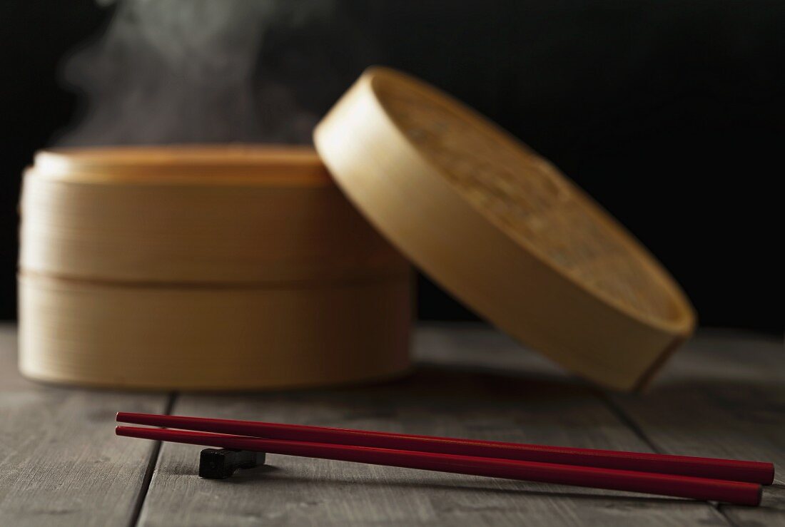 Chopsticks in front of a bamboo steamer