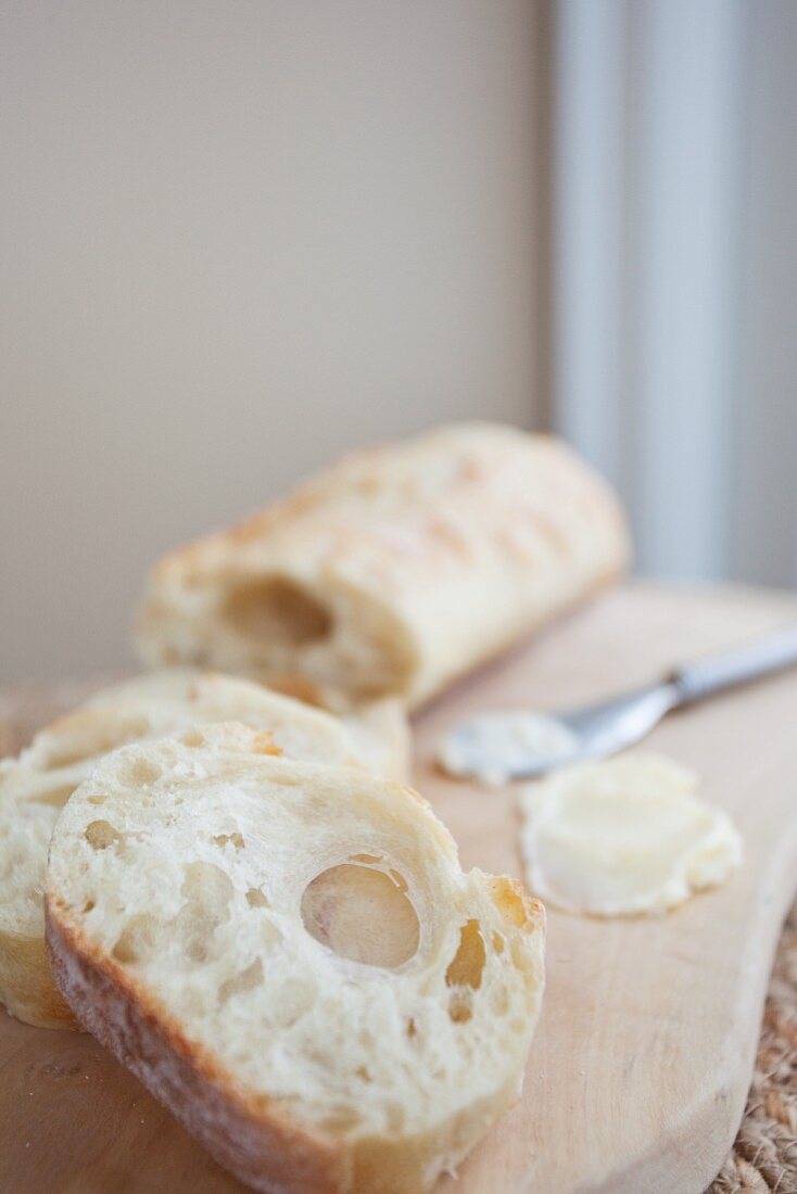 Ciabatta und Butter auf Schneidebrett