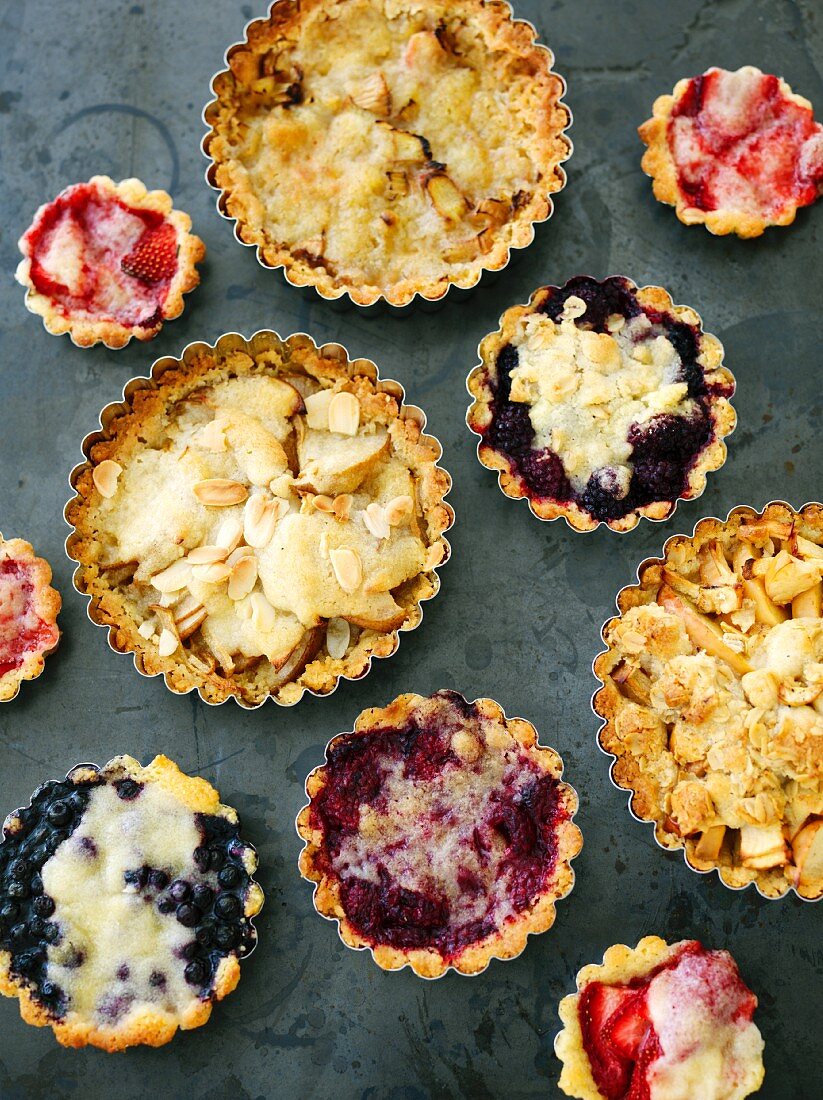 Various tartlets: berry tartlets, crumble tartlets and tartlets topped with slivered almonds