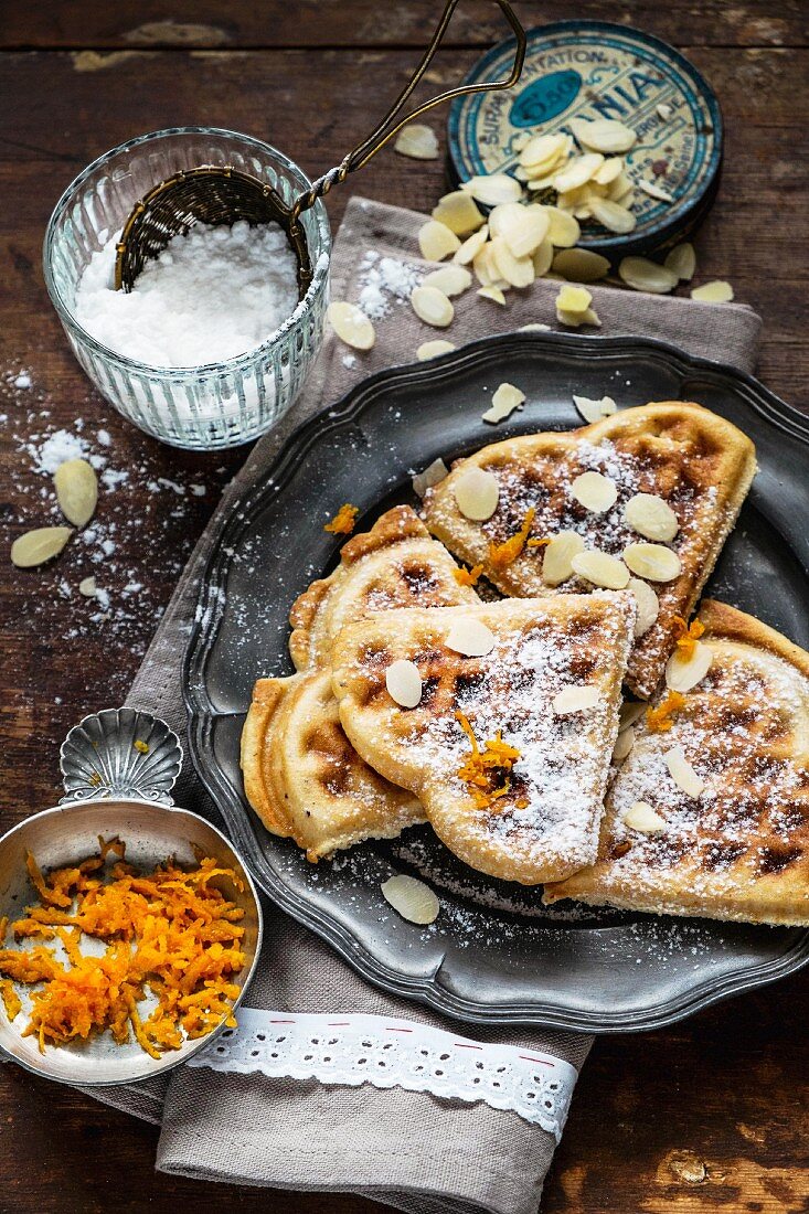 Heart-shaped waffles with slivered almonds and orange zest