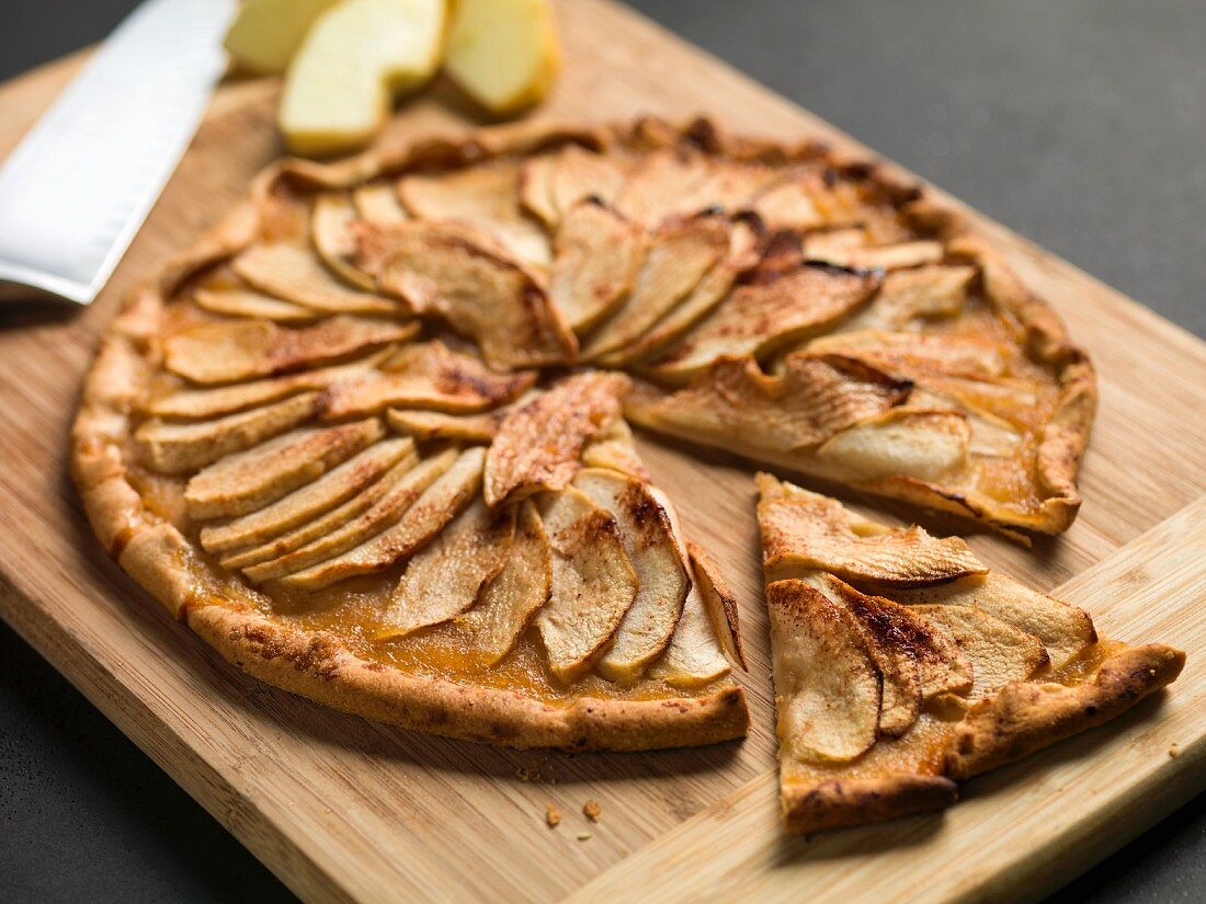 Apple tarts made with finely sliced apples on a chopping board