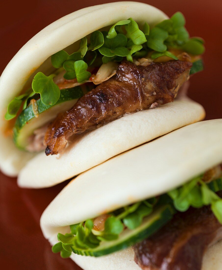 Gedämpfte Bao-Brötchen mit Schweinefleisch, Gurken und Kresse (China)