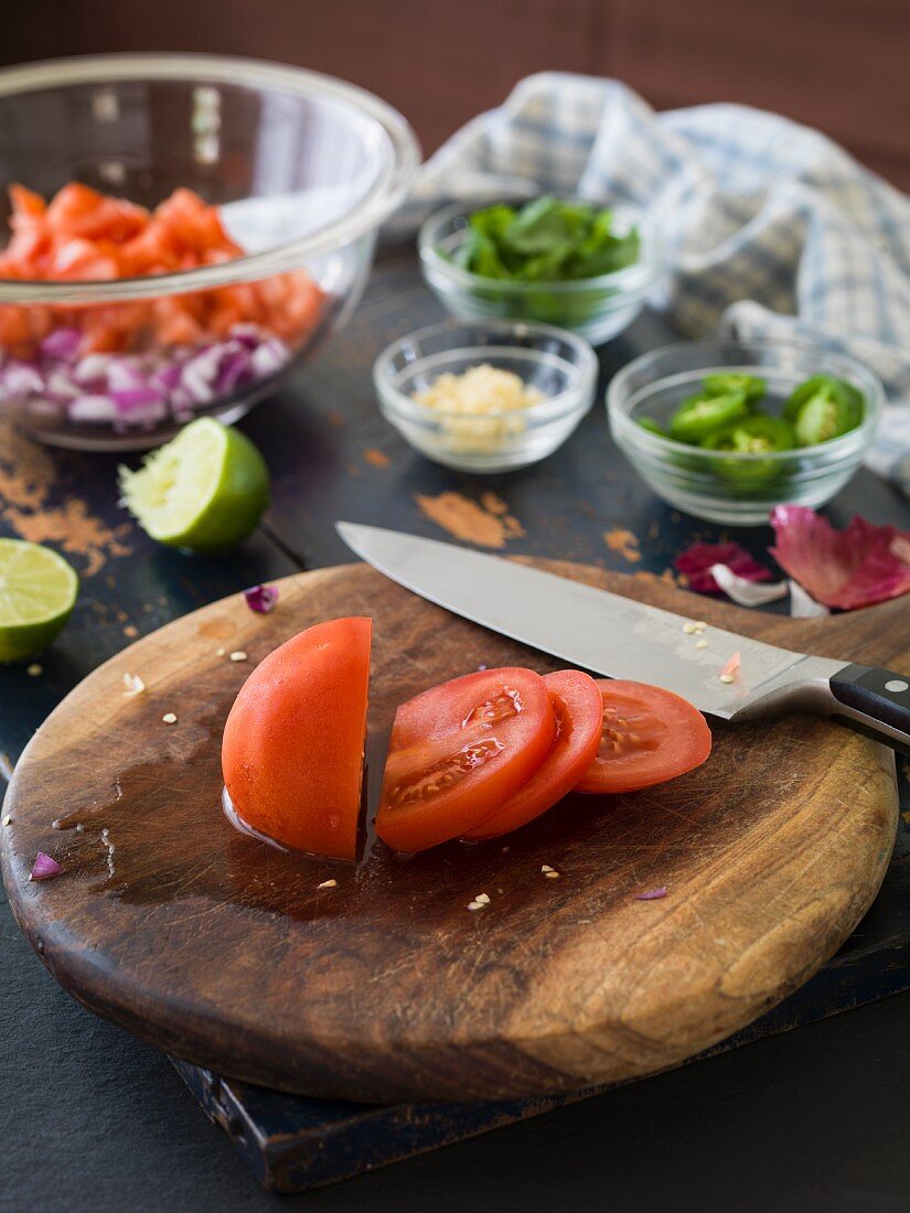 Freshly sliced tomatoes on a chopping board to be used to make tomato salsa