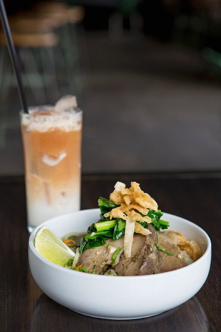 Noodles with pork and a cocktail made with coconut milk