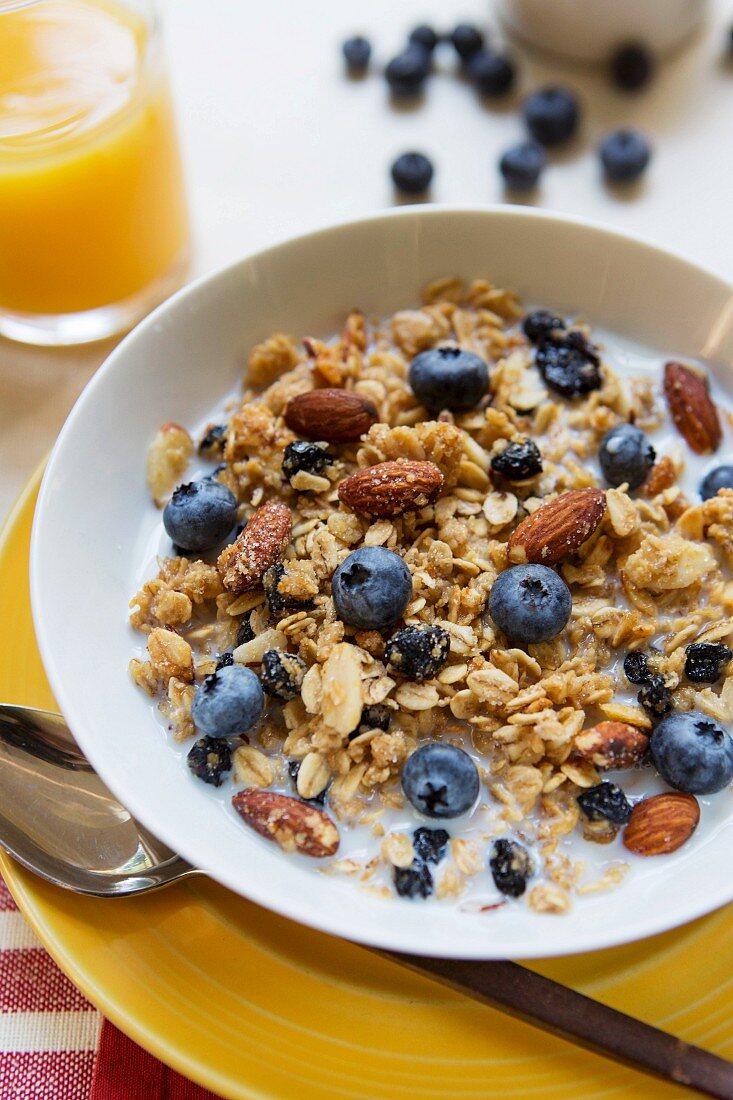 Muesli with almonds and blueberries and a glass of orange juice