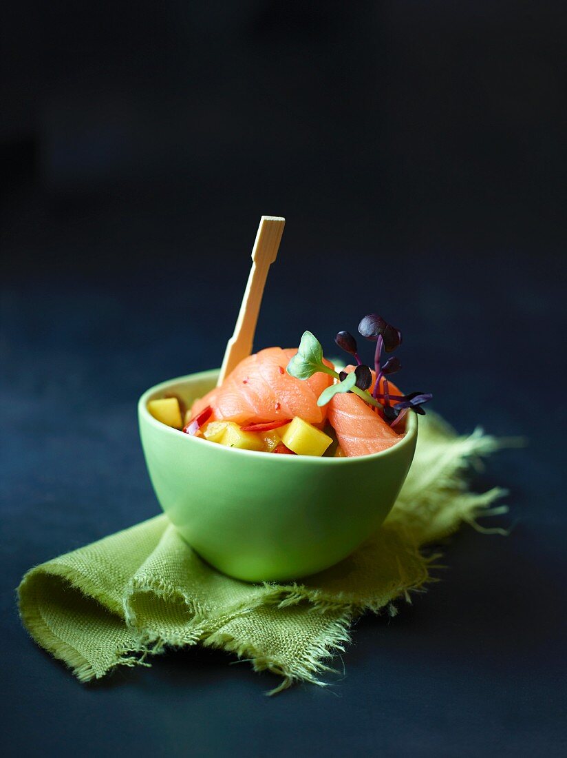 A bowl of raw salmon with mango salsa