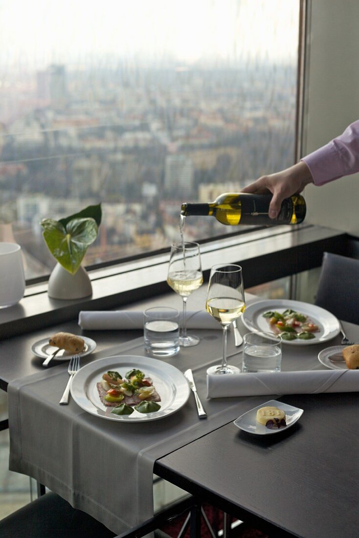 Gedeckter Tisch im Fernsehturm-Restaurant mit Ausblick auf die Stadt
