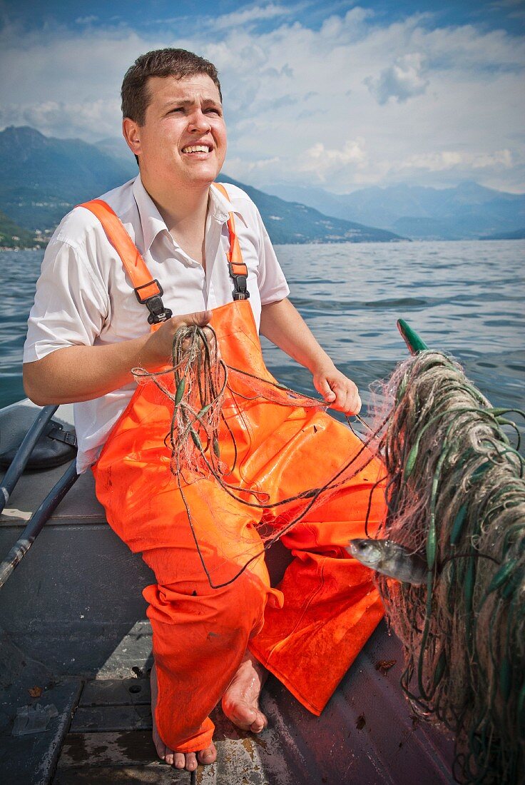 Fischer im Boot hält Netze