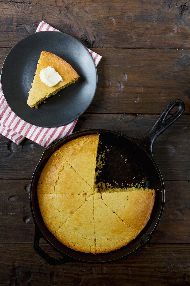 Cornbread in a frying pan and a slice of cornbread with butter