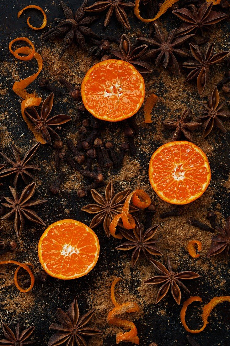 Mandarinenhälften, spiralförmige Orangenschalen, Sternanis und Gewürznelken