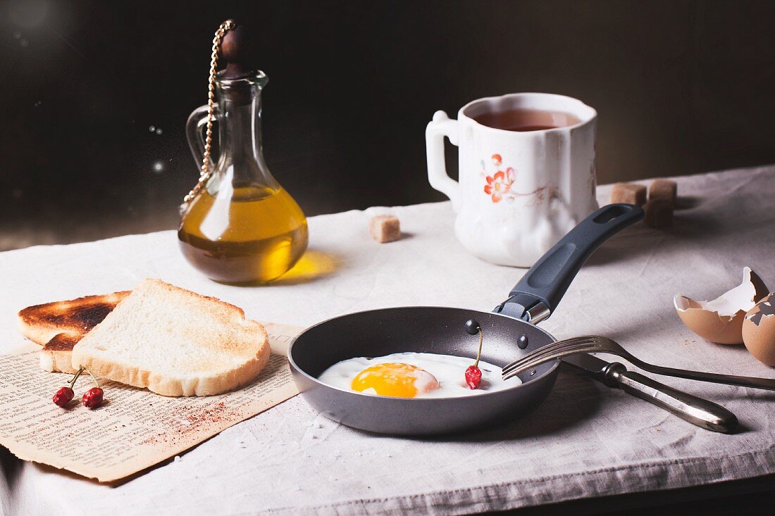 Frühstück mit Spiegelei, Toast, Chilischoten und Olivenöl