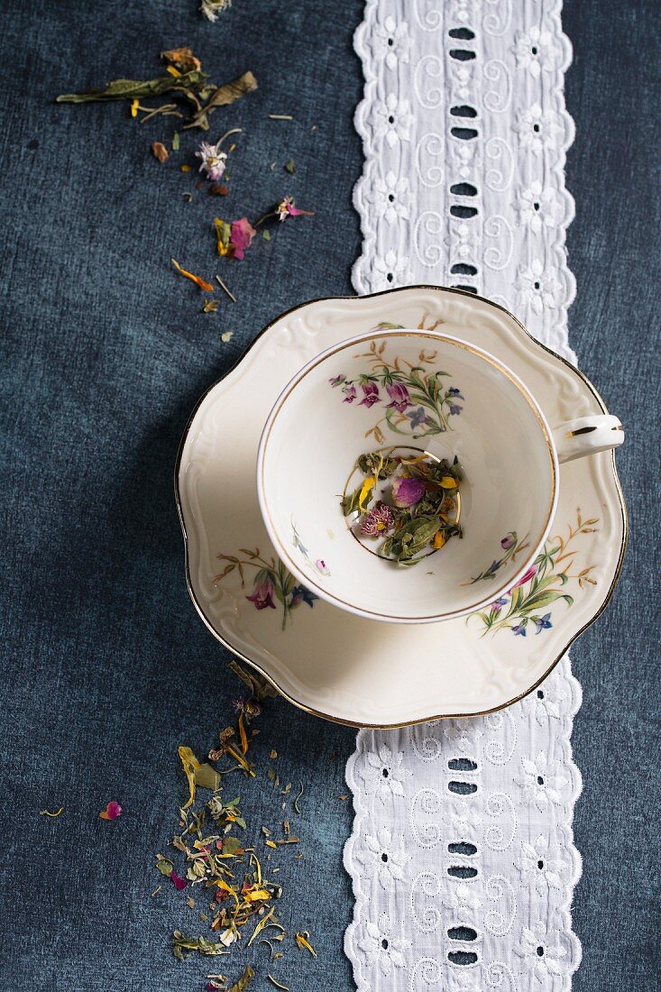 A herbal tea mixture with various flowers in an old-fashioned cup