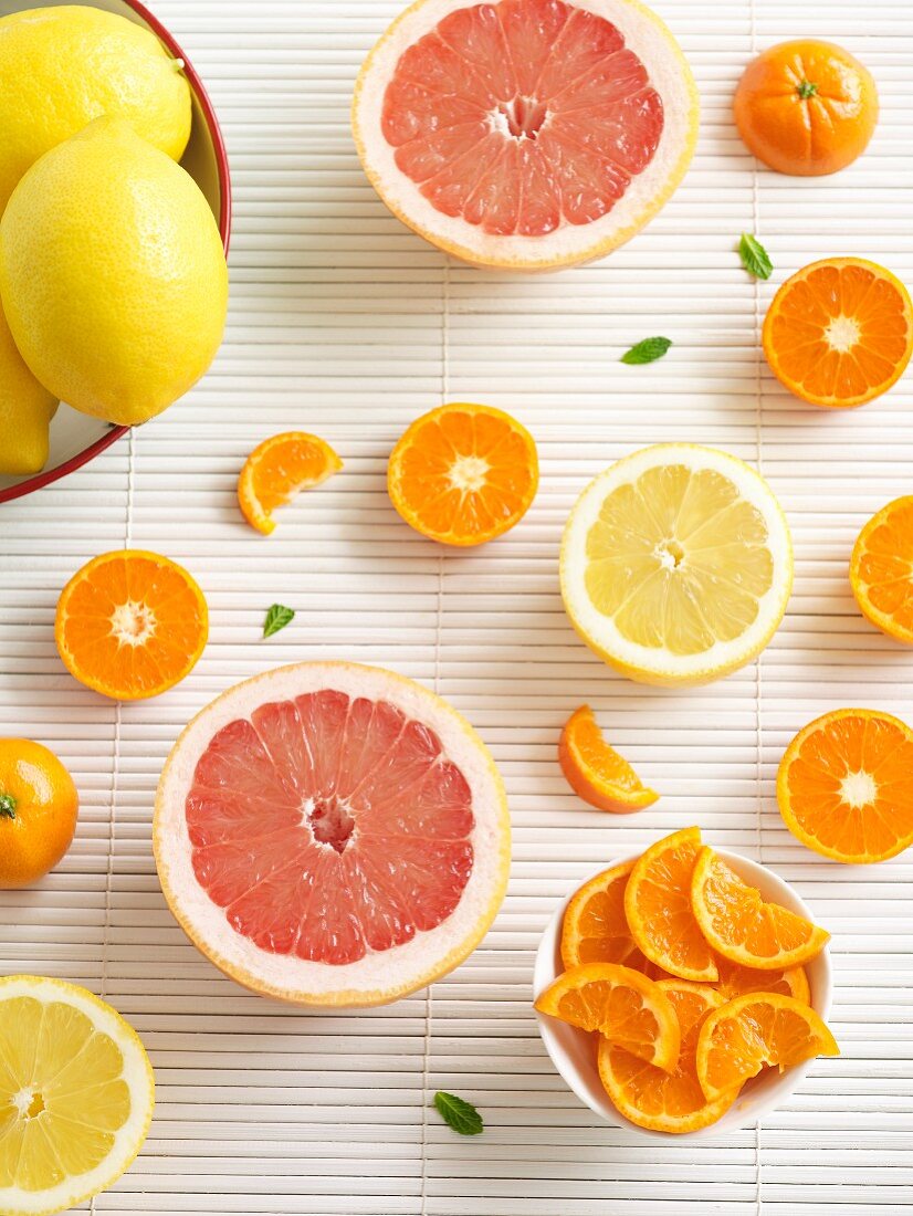 Various citrus fruits (whole, halved and sliced)