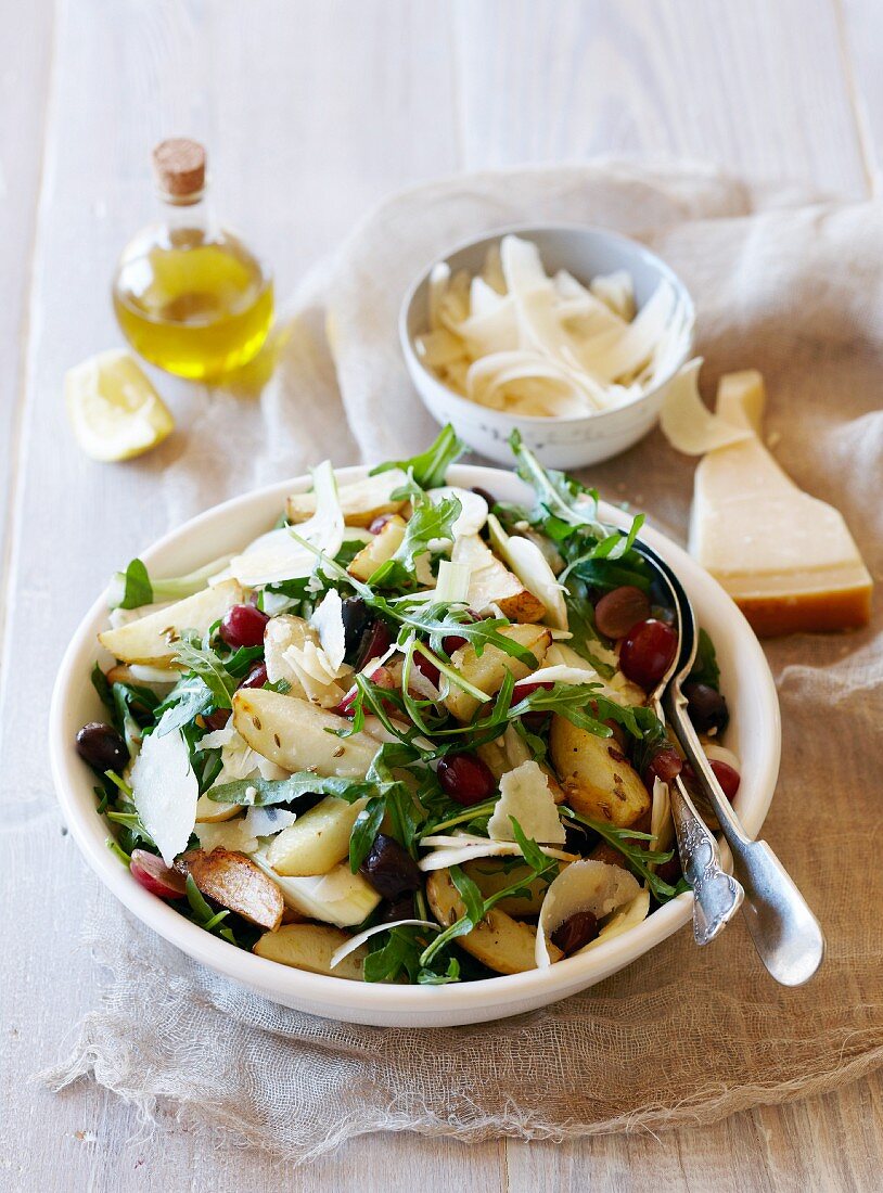 A salad with roast potatoes, grapes, fennel and parmesan