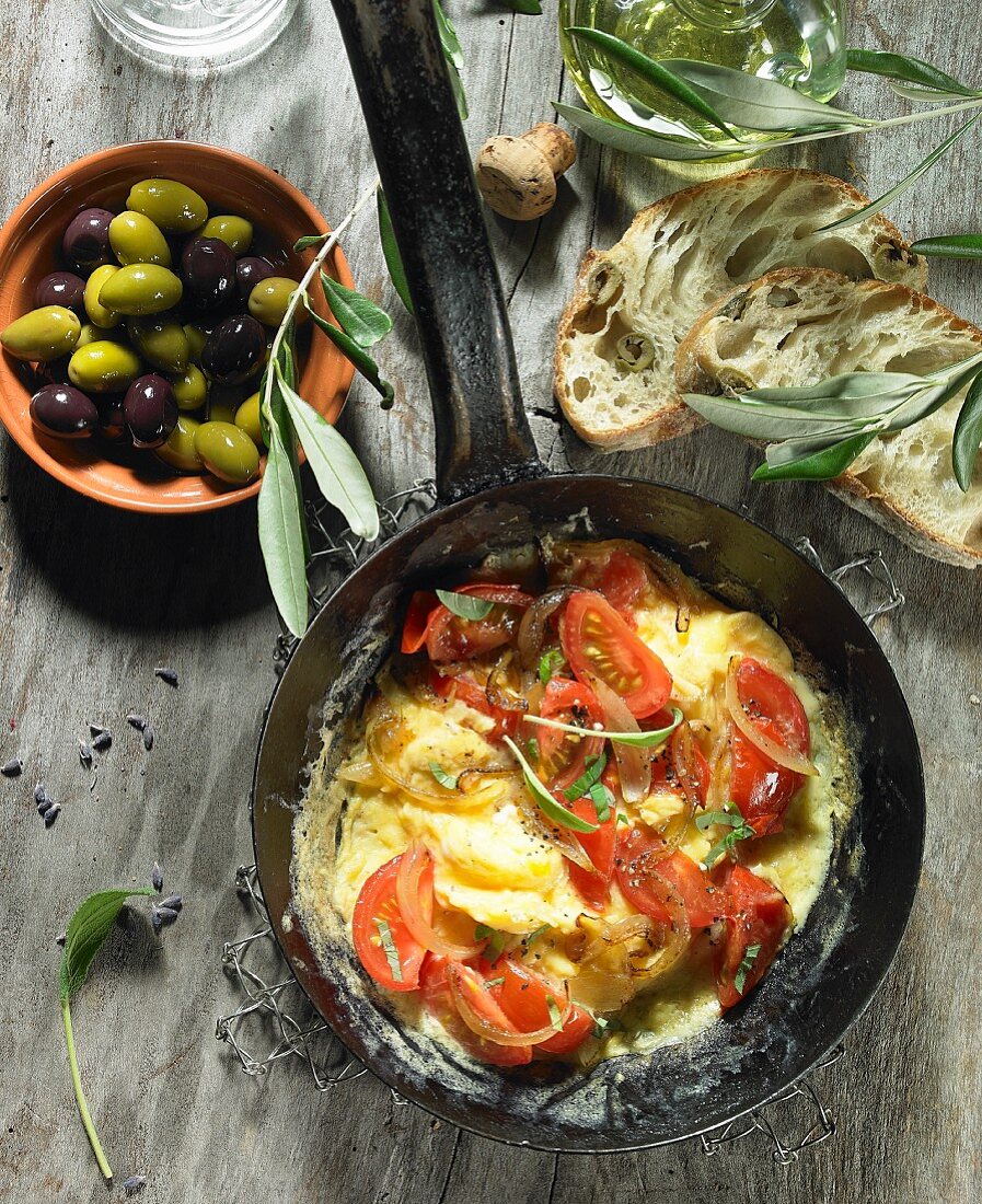 Tomato scrambled eggs with onions, black and green olives, olive oil, an olive spring, olive ciabatta and lavender