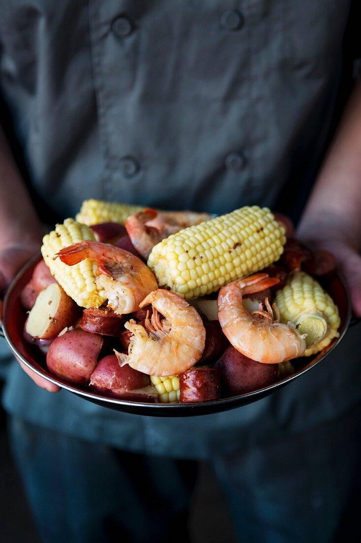 A rustic stew made with potatoes, corn cobs, sausages and prawns