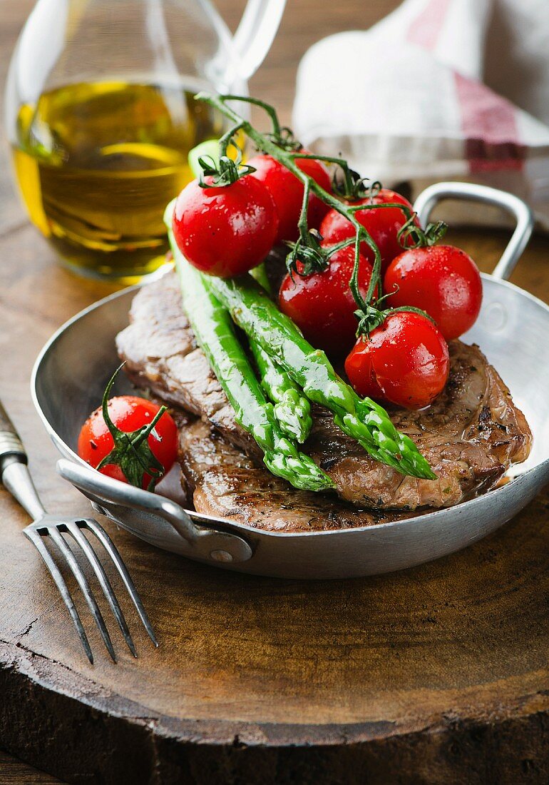 Beef steak with asparagus and tomatoes