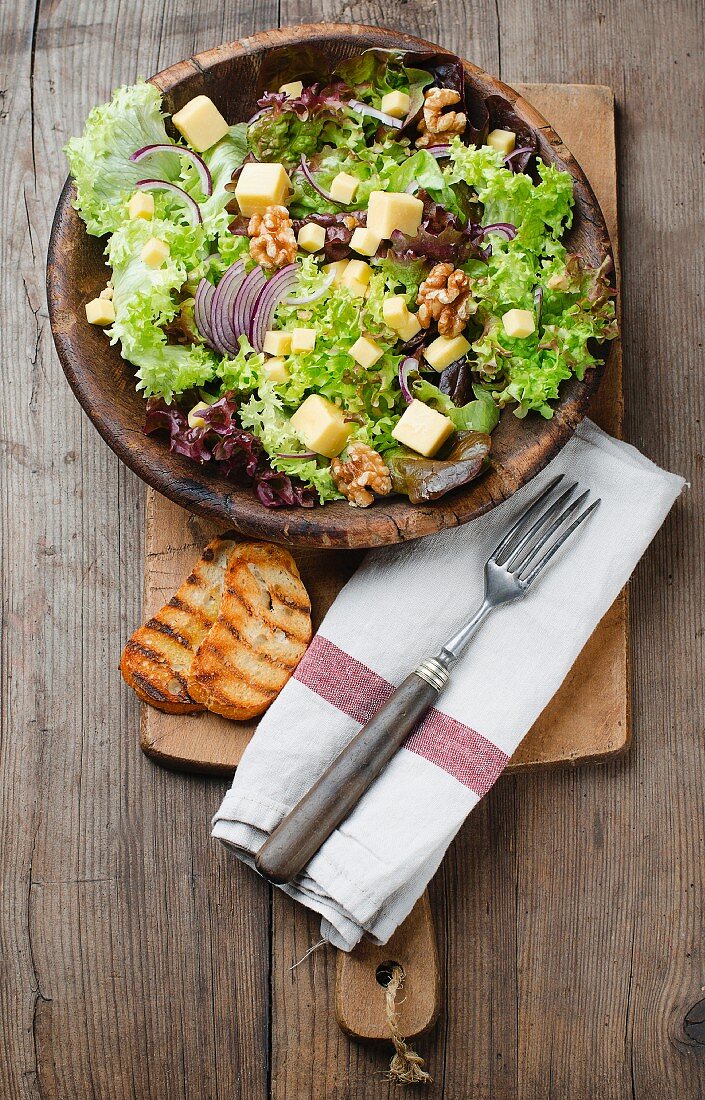 Mixed leaf salad with cheese, walnuts and onions (seen from above)