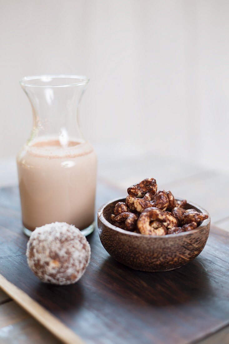 Cashewkerne mit Kakaopulver, Mandeldrink und Kokos-Dattel-Bällchen