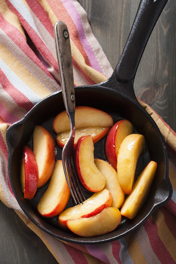 Caramelised apple slices in a frying pan